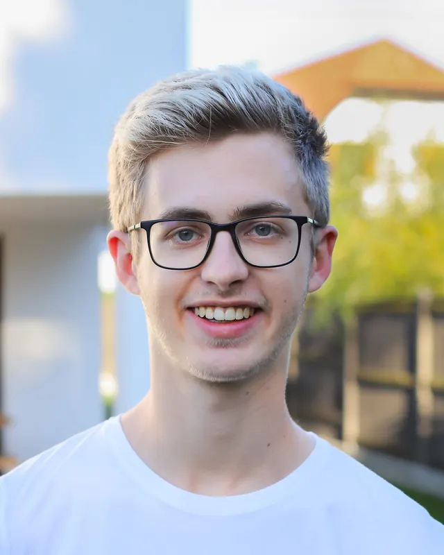 Fabian, der zackig entwickelt, lächelnd im Freien